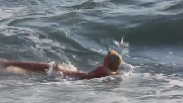 Жінка в купальнику в морі під хвилею серфінгу — стокове відео