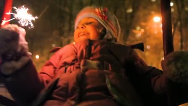 Little girl balanceert en sparkler in de hand houden, nacht buiten — Stockvideo