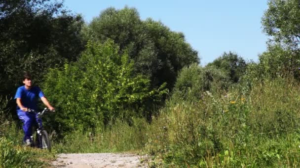 Hombre a su vez traje deportivo azul ir a conducir en bicicleta en el camino en el parque — Vídeos de Stock