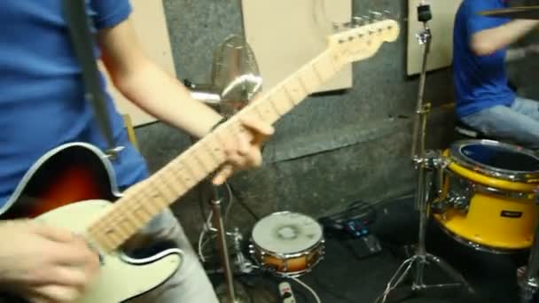 Музыкальная группа из пяти человек, играющая в студии, движущаяся камера — стоковое видео