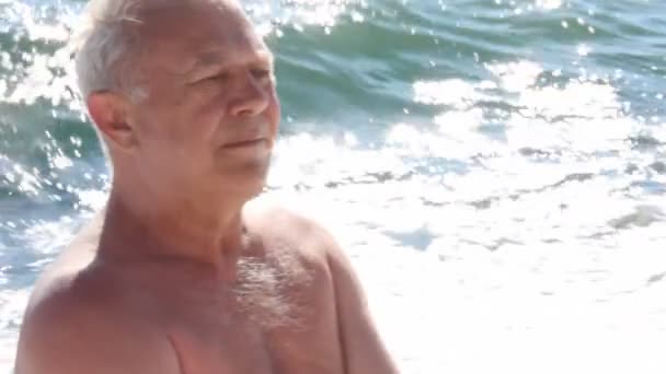 Portrait d'homme âgé assis dans la mer surf pause contre son dos — Video