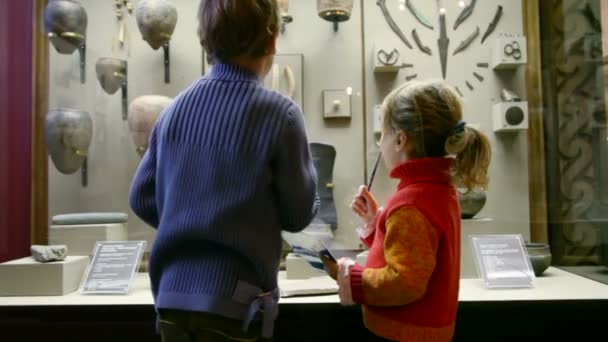 Menino e menina com lápis e caderno no museu de história — Vídeo de Stock