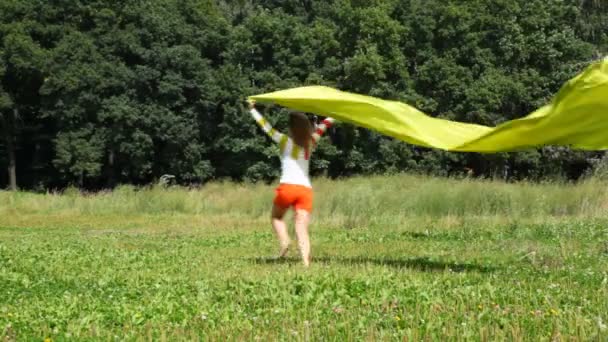 Jovem mulher bonita com seda amarela correndo ao ar livre da câmera — Vídeo de Stock