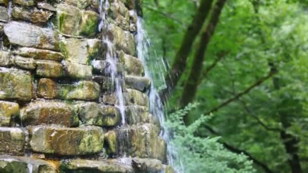 Artificial stone cascades waterfall fountain in park, panning downwards — Stock Video