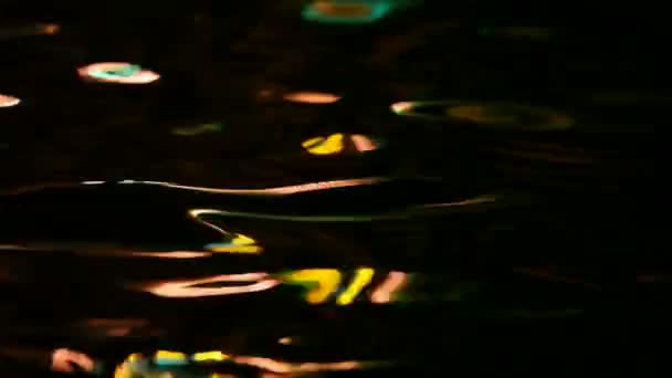 Abstracte beweging achtergrond, lichte kleur reflecties op donkere golvend water — Stockvideo