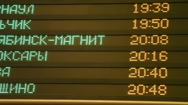 Panning of display with train schedule in railroad station — Stock Video