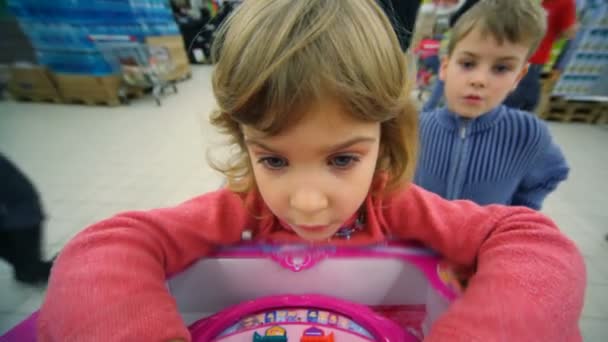 Niña y niño jugando juego de lógica en el centro comercial — Vídeos de Stock