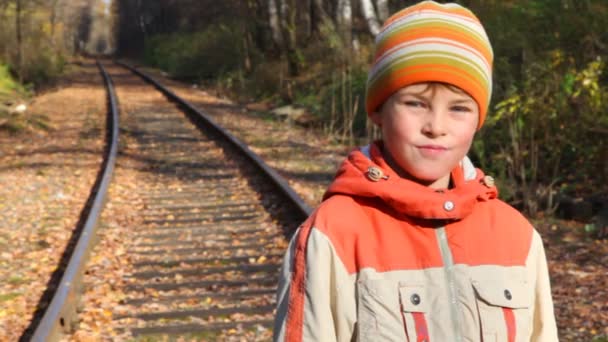 Portret van jongen staande op railroad tracks — Stockvideo