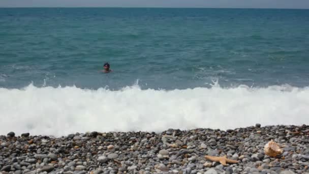 Hombre nada en el mar, luego salió del agua y viene a la cámara — Vídeos de Stock