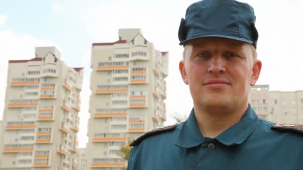 Retrato del oficial del servicio de rescate de pie contra la urbanización — Vídeos de Stock