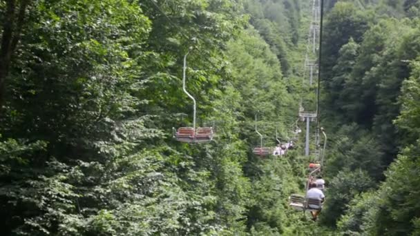 Tourists on moving funicular above mountain forest — Stock Video