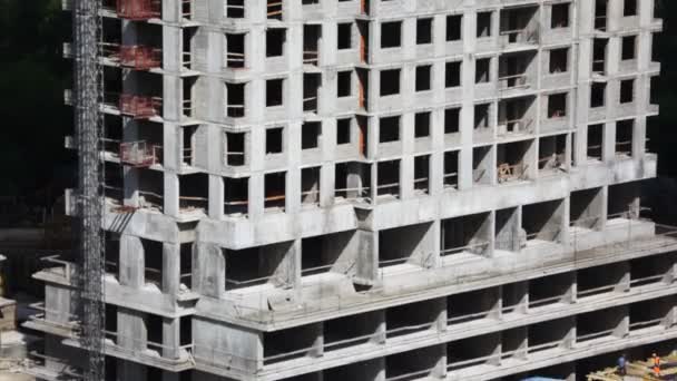 Blick von unten nach oben auf ein im Bau befindliches Hochhaus mit Kran oben — Stockvideo