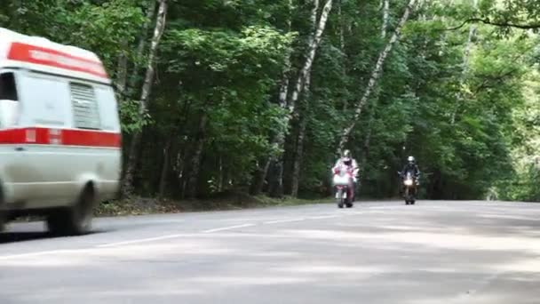 Два мотоциклиста, первая помощь и грузовик на дороге — стоковое видео