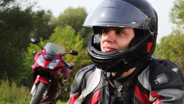 Motorcyklister sitter nära motorcykel, se och vrid huvudet — Stockvideo