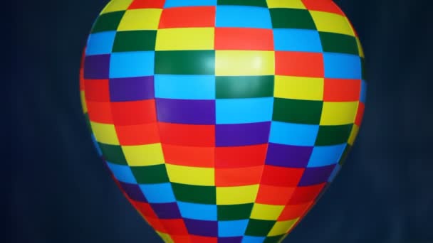 Часть цветной игрушки воздушный шар вращается на голубом фоне — стоковое видео