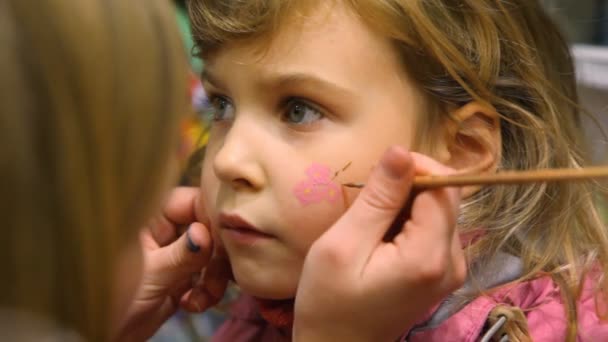 Niña con pintura de color de flor en la cara — Vídeos de Stock