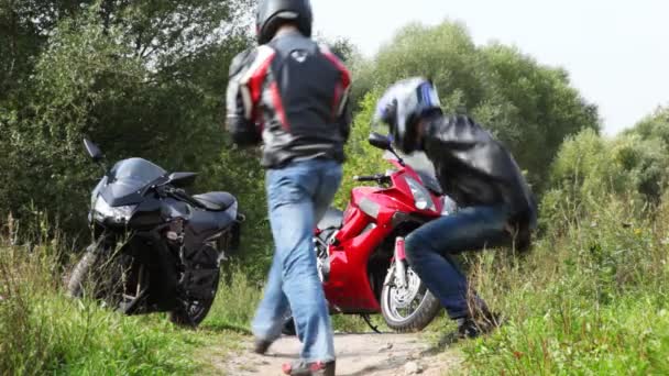 Twee zit op gras, dan zitten op motorfietsen en verlaten — Stockvideo