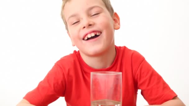Μικρό αγόρι παίρνει γυαλί, πίνει νερό από αυτό και χαμόγελα — Αρχείο Βίντεο