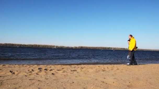 Uomo e due donne che tengono per mano, girano e corrono sulla spiaggia del fiume — Video Stock