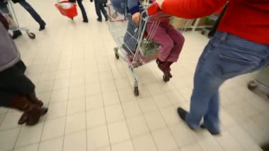 Alışveriş arabasıyla alışveriş merkezine giden bir kadın.
