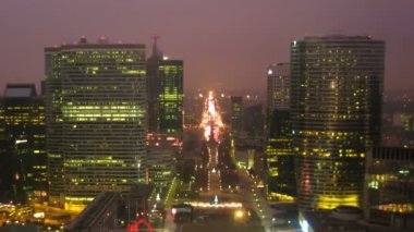 Movement in a night city, skyscrapers are lengthways road. 