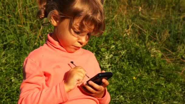fille dans le parc, tenir PPC dans les mains et le toucher avec des stylos en été 