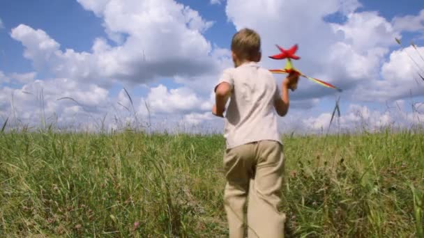 garçon courir à travers le terrain avec l'avion 