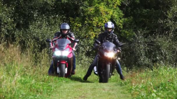 Two bikers on their motorcycles start on footpath together — Stock Video