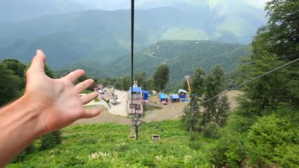 Movendo funicular acima da floresta nas montanhas, duas mãos dando polegares para cima — Vídeo de Stock