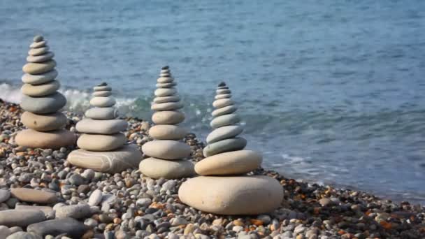 Piedra pila en la costa de guijarros, agitando el mar en el fondo — Vídeos de Stock