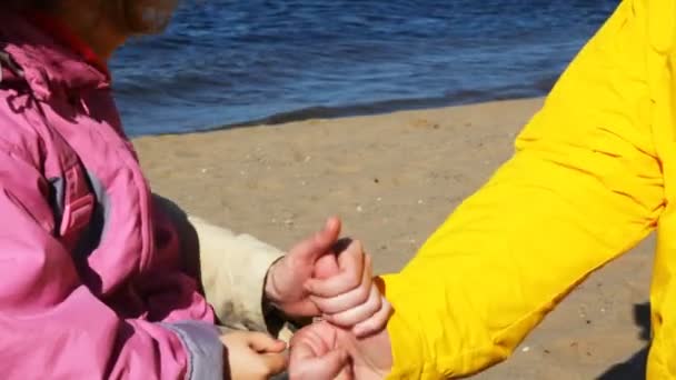 Family plays river beach, build fists chain from below upwards — Stock Video