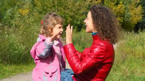 Молода жінка з маленькою дівчинкою грає в торт — стокове відео