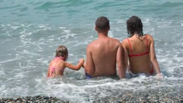 Two womans and man holds inflatable mattress walking on beach — Stock Video