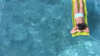 su havuzu şişme yatak yatan kadın