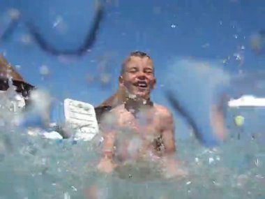 Açık Yüzme havuzunda mutlu çocuk kamera su sıçramalarına