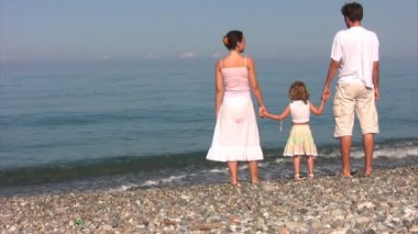 Aile karşı deniz kıyısında duruyor.
