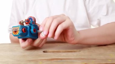 Clockwork robot ileri yürüyüşleri, davul çalıyor ve deliğin içine stepping düşüyor ama çocuk yol açtı