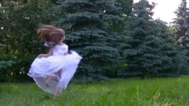 Kız, çim ve iğne yapraklılar park dansları balede giymiş.