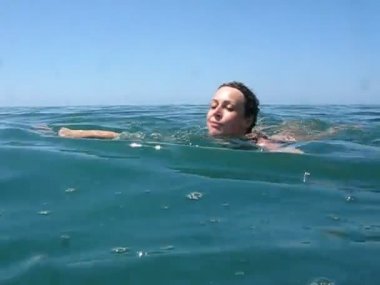 Yüzme elbiseli kadın denizde yüzüyor