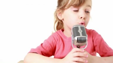 Kız masada oturur ve mikrofon şarkı söylüyor