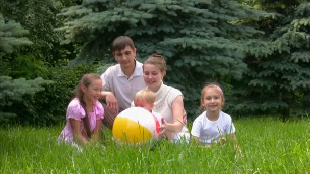 Familia con pelota se sienta en el parque de verano — Vídeos de Stock