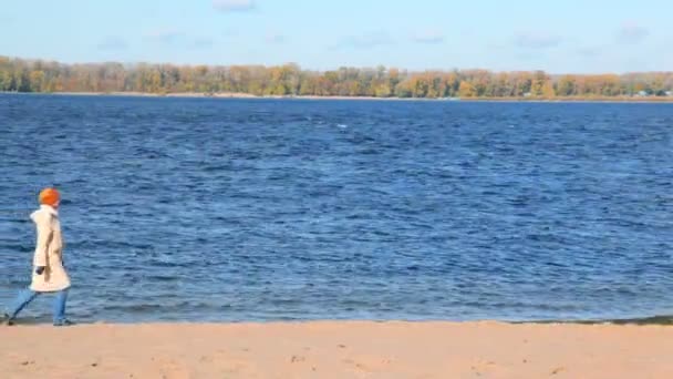 Kvinnan promenader längs sandstranden bank — Stockvideo