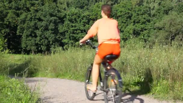 Vrouw rides fiets in park — Stockvideo