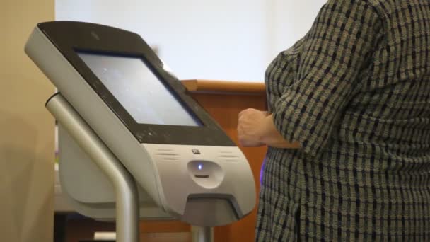 Mujer utiliza terminal de ordenador con pantalla táctil, tomar cupón de auto-cola en el banco — Vídeos de Stock