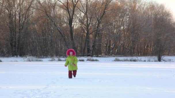 Girl runs from camera in wintry snowfield, and comes back — Stock Video