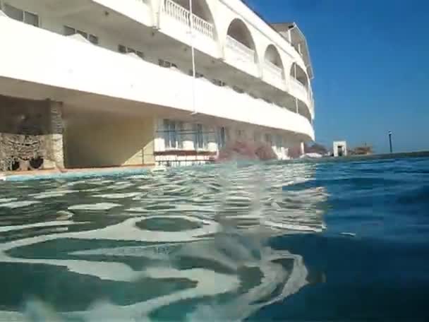 Cámara que se mueve sobre la superficie del agua en la piscina al aire libre — Vídeos de Stock