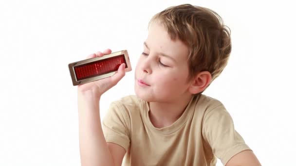 Jongen in beige t-shirt heeft een informatie led display met word mama en brengt het aan het camcoder — Stockvideo