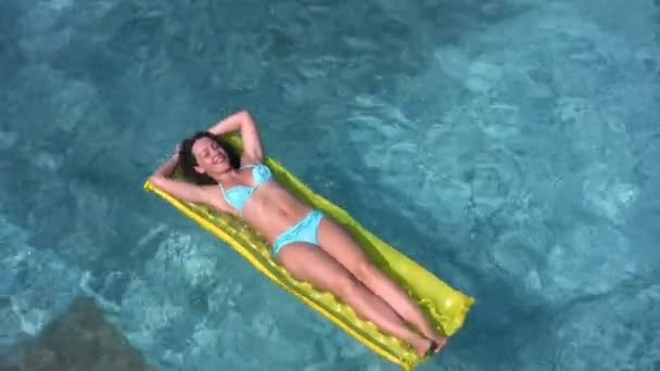 Mulher encontra-se no colchão inflável e rugindo na piscina — Vídeo de Stock