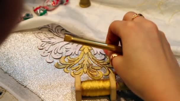 Weibliche Handstickerin mit Goldfaden und Spitzennadel auf Stoff — Stockvideo