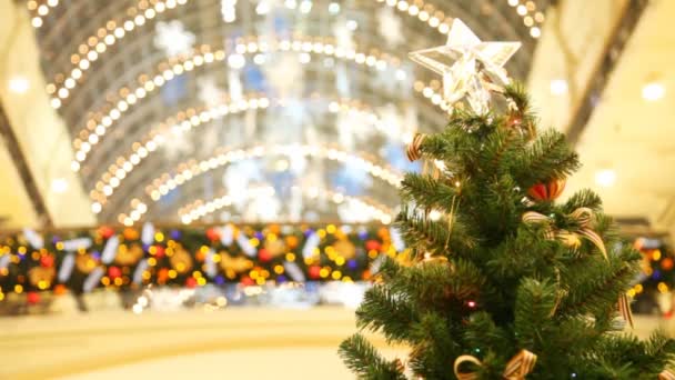 Árbol no natural con arcos y estrella en la parte superior contra techo de cristal del centro comercial — Vídeos de Stock